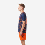Men's custom orange and navy soccer uniform side profile showing lightning crack graphic from shoulder to hem and orange shorts