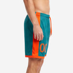 Side view of custom orange soccer shorts showing full-length orange vertical panel and teal body with elastic drawcord waistband