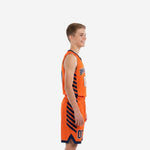 Side view of custom orange and navy youth basketball uniform showing diagonal stripe detail on jersey side panel and shorts leg