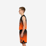 Side view of orange and black youth basketball uniform showing hex-dot gradient on jersey and shorts with bound armhole and elastic waistband