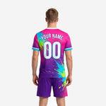Close detail of neon splash burst print on custom pink soccer uniforms showing cyan and lime green accents on purple base