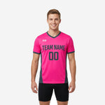 Custom pink soccer training jersey with charcoal side panels and V-neck collar, front view on male model