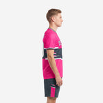 Pink soccer uniforms side view showing glitch stripe graphic on charcoal midsection band and charcoal shorts