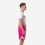 Custom pink soccer uniforms side view left showing continuous dot-burst gradient from white chest to hot pink hem on jersey and shorts