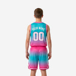 Opposite side view of custom pink and teal youth basketball uniforms showing shorts side stripe and gradient detail on jersey