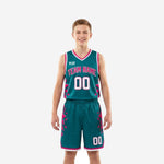 Custom pink youth basketball uniforms in teal with geometric triangle pattern, showing front and back of the full 2-piece set including jersey and shorts