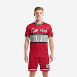 Custom plain soccer uniforms in Crimson Red with black and white dot-burst chest panel, front view on male model