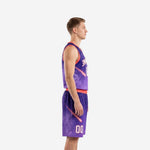 Side view of custom purple basketball uniform showing coral armhole binding, galaxy comet graphic on jersey and matching shorts