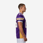 Side view of custom purple football jersey showing gold side panel running from underarm to straight hem and stripe sleeve detail