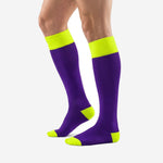 Over the calf custom purple and gold soccer socks with neon yellow heel and toe cap, offset side view