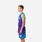 Side view of custom purple teal youth basketball uniforms showing halftone dot gradient pattern on jersey and shorts
