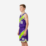 Side view of purple and lime youth basketball uniform set showing diagonal stripe flowing from jersey through shorts on youth boy