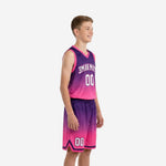 Side view of custom purple and pink youth basketball uniform set showing gradient fade and chevron hem trim on shorts