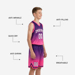 Shorts detail of custom purple and pink youth basketball uniform set showing chevron V-trim hem and sublimated hex texture