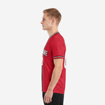Custom red and black soccer jersey right side view showing three-stripe crew neck trim and sublimated red body on adult male model