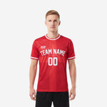 Custom red and white soccer jersey with white contrast crew neck trim and team name printed on chest, front view on male model