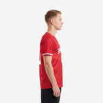 Custom red and white soccer jersey showing white sleeve cuff trim and athletic fit, left side view on male model