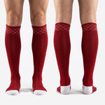 Full-length pair of custom red and white soccer socks laid flat showing argyle cuff and two-tone design