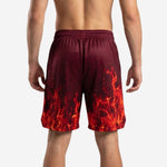 Front view of custom red basketball shorts showing deep maroon waistband, ribbed elastic band, and photorealistic flame graphic rising from the hem