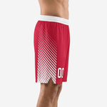 Custom red and white sublimated basketball shorts showing diagonal stripe side panel and hem split, left side view on male model