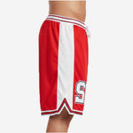 Side view of custom red and black basketball shorts showing full-length white side panel V-notch hem split and layered stripe trim detail