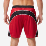 Custom red soccer shorts rear view showing concentric curved black arc panels with white piping on male model