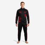 Custom red and black soccer tracksuit front view showing full-zip jacket with red speed-stripe sublimation print and matching tapered pants on male model