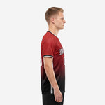 Custom red soccer shirt side view showing dark red to black gradient fade and white mesh side panel on adult male model