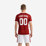 Back view of custom red soccer uniform with dark red jersey and white shorts worn by adult male model