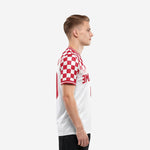 Red and white checkered soccer jersey side view showing checkerboard sleeve and pure white lower body on male model