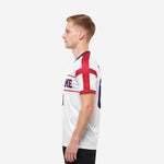 Custom red and white soccer jersey with red cross panel and red sleeve cuff band shown from right side angle
