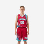 Custom red youth basketball uniforms front and back showing teal dot-burst pattern, arched team name, and matching shorts with teal hem trim