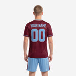 Close detail of maroon sublimated soccer jersey showing all-over stamp motif pattern and powder blue sleeve cuff accent