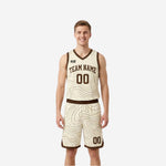 Cream side of custom reversible basketball uniform sets showing brown topographic pattern, brown trim, and arced team name on chest