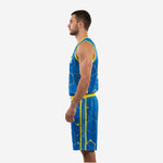 Side view of royal blue custom sublimated basketball uniform showing yellow armhole binding and full hex pattern on jersey and shorts