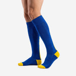 Over the calf custom royal blue soccer socks with gold toe box shown in profile view on male model