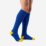Men's custom royal blue soccer socks with gold accent panels shown from side angle on adult model