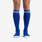 Custom royal blue soccer socks with double white stripe cuff band, front view on adult male