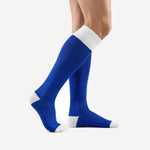 Royal blue soccer socks with white contrast cuff, side angle showing over-the-calf length on adult model
