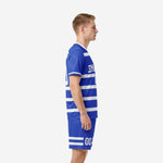 Custom blue soccer uniform side view showing white stripe pattern across jersey midsection and shorts hem detail