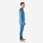 Custom blue soccer tracksuit side view showing navy contrast stripe on jacket sleeve and tapered pant leg on adult male model