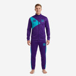Custom soccer club tracksuit in Royal Purple and Teal with diagonal chest panel, full-zip jacket and tapered pants, front view on male model