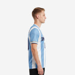 Side view of custom soccer shirts mens showing light blue and white stripe pattern and gold trim sleeve cuff