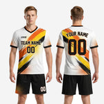 Custom black soccer shorts with orange and yellow halftone dot burst print at hem, part of white and orange men's soccer uniforms for teams package