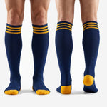 Full length view of custom gold soccer socks in Navy Blue worn by adult male model showing over the calf fit above shin guard line