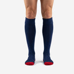 Custom soccer socks navy blue with red contrast heel and toe, front view on adult male model