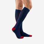 Custom soccer socks navy blue with red side accent stripe and red heel, side angle view on adult male model