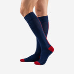 Custom soccer socks navy blue three-quarter view showing red toe block and ribbed cuff on adult male model