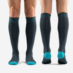 Custom soccer socks in teal and charcoal full length view from cuff to toe on mens adult model