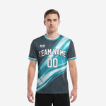 Custom soccer tops in teal and charcoal gradient with team name and number on the front, worn by adult male model